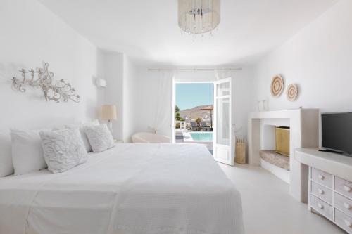 凯勒里瓦迪Mykonian Atmosphere的白色卧室设有一张白色大床和电视。