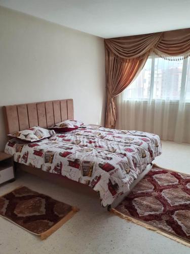 斯法克斯Appartement confortable - Sfax centre的一间卧室配有一张带被子的床和一扇窗户