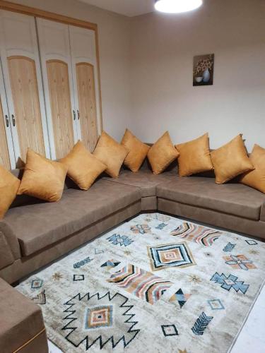 斯法克斯Appartement confortable - Sfax centre的棕色沙发、枕头和地毯