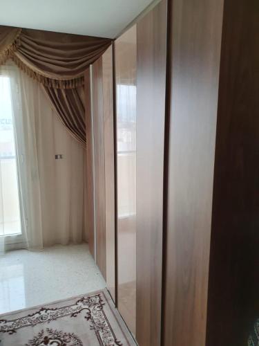 斯法克斯Appartement confortable - Sfax centre的带窗户的客房内的镜子衣柜