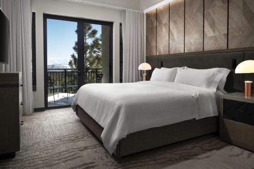 马姆莫斯湖猛犸湖威斯汀莫纳奇度假酒店的一间带一张白色大床的卧室和一个阳台