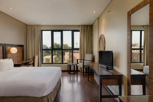 伊凯贾普罗蒂亚万豪Protea酒店的酒店客房配有一张床、一张书桌和一台电视。