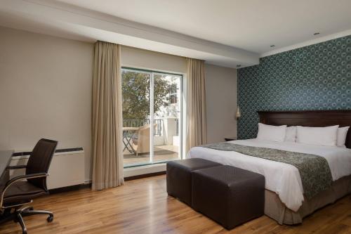 贝尔维尔开普敦德班维尔万豪Protea酒店的卧室配有床、椅子和窗户。