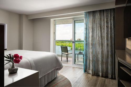 坎昆The Westin Cancun Resort Villas & Spa的酒店客房设有一张床和一个大窗户