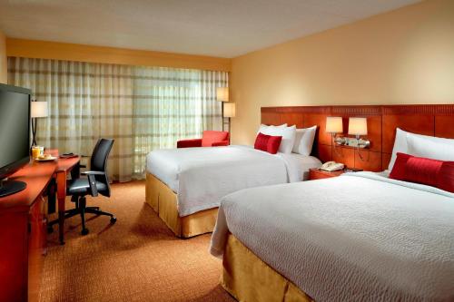 哥伦布哥伦布万怡酒店的酒店客房设有两张床、一张桌子和一台电视。