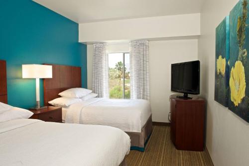 棕榈荒漠棕榈沙漠原住客栈的酒店客房设有两张床和一台平面电视。