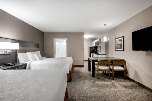 白鱼镇TownePlace Suites by Marriott Whitefish的酒店客房设有两张床和一张桌子
