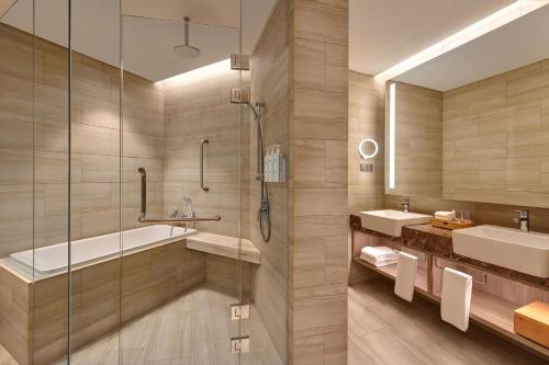 实达阿南Courtyard by Marriott Setia Alam的带浴缸、水槽和淋浴的浴室