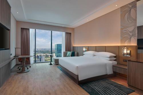 实达阿南Courtyard by Marriott Setia Alam的卧室设有一张白色大床和大窗户