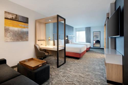 印第安纳波利斯SpringHill Suites by Marriott Indianapolis Keystone的酒店客房设有一间带一张床和一张沙发的卧室
