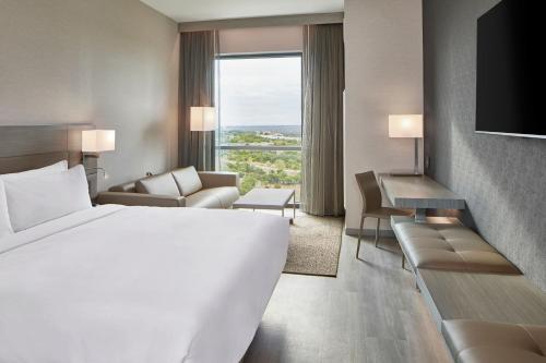 奥斯汀AC Hotel by Marriott Austin Hill Country的酒店客房设有一张白色大床和一个窗户。