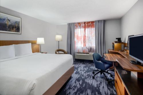 盐湖城盐湖城市中心费尔菲尔德酒店及套房的酒店客房配有一张床和一张带电脑的书桌
