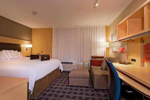 道奇城道奇城万豪广场套房酒店的酒店客房设有一张大床和一张沙发。