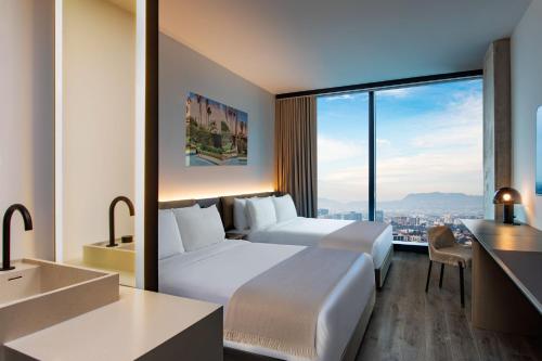 洛杉矶AC Hotel by Marriott Downtown Los Angeles的酒店客房设有两张床和大窗户。