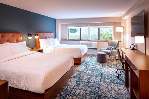 诺伍德Four Points by Sheraton Norwood Conference Center的酒店客房配有两张床和一张书桌