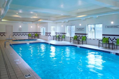 弗兰肯默斯弗兰肯默斯万豪春季山丘套房酒店的一个带绿色桌椅的大型游泳池