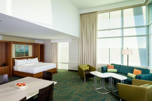 肯纳威克肯纳威克三城万豪春岭套房酒店的酒店客房配有一张床、一张沙发和椅子。