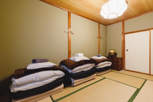 松本Couch Potato Hostel - Vacation STAY 88241的带三张床和毛巾的房间