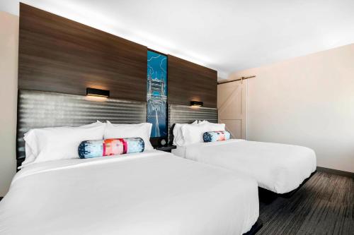 纽波特纽波特堤坝雅乐轩酒店的酒店客房内设有两张白色的床