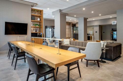 威尔明顿威尔明顿市中心喜来登套房酒店的一间会议室,配有一张大木桌子和椅子