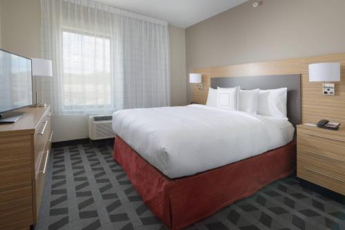 隆娜特里南丹佛/隆特里万豪广场套房酒店的一间酒店客房,配有一张大床和一台平面电视