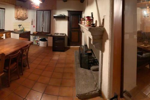 BrioneRustico Cà Laura的一间位于客房中间的带壁炉的厨房