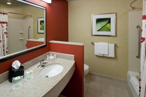 特克萨卡纳-德克萨斯特克萨卡纳万怡酒店的一间带水槽、卫生间和镜子的浴室