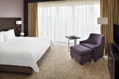 利雅德玛利雅特外交区万怡利雅得酒店的配有一张床和一把椅子的酒店客房