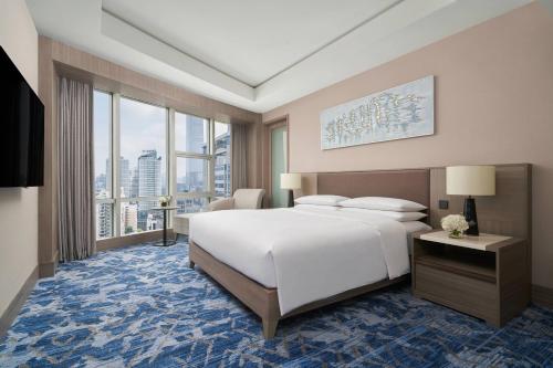 南宁南宁鑫伟万豪酒店的卧室设有一张白色大床和大窗户