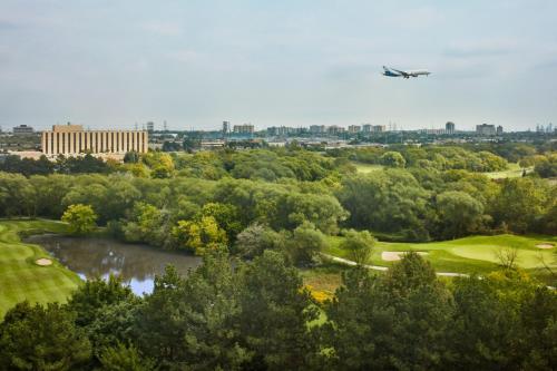 多伦多多伦多机场万豪酒店的飞机飞越一个有湖泊的高尔夫球场