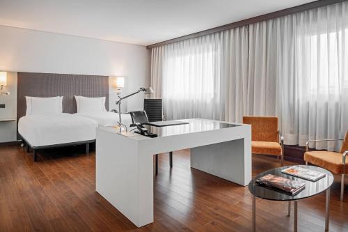 波尔图波尔图万豪AC酒店的配有一张床和一张书桌的酒店客房