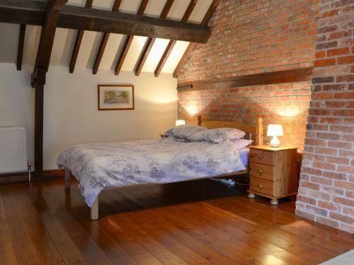 BawdeswellChurch Farm Barn - Ukc3739的一间卧室设有一张床和砖墙