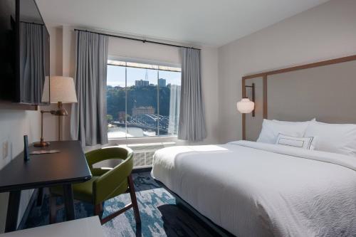 匹兹堡Fairfield by Marriott Pittsburgh Downtown的配有一张床、一张书桌和一扇窗户的酒店客房