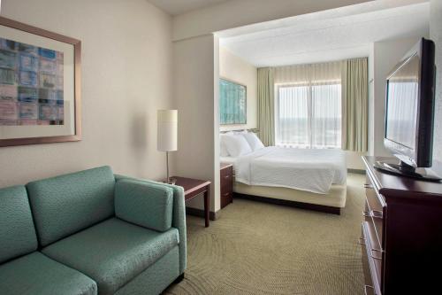 普利茅斯会议费城普利茅斯春之山丘套房酒店的酒店客房配有床、沙发和电视。