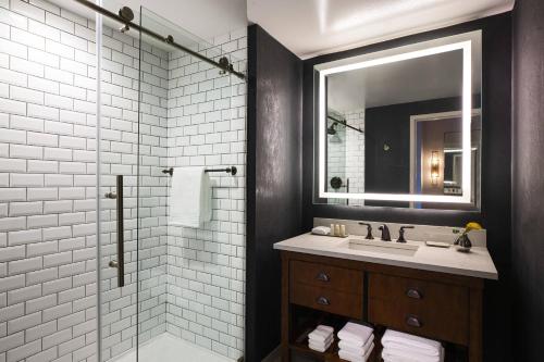 费城费城市中心万丽酒店的浴室配有盥洗盆和带镜子的淋浴