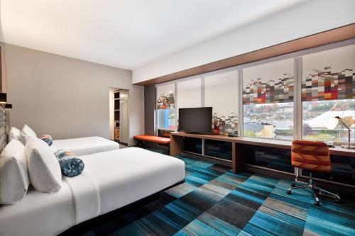 西塔科西雅图塔克机场雅乐轩酒店的酒店客房设有两张床、一张桌子和一台电视。