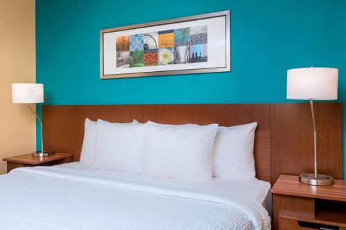 维多利亚维多利亚费尔菲尔德酒店的一张位于酒店客房的床铺,拥有蓝色的墙壁