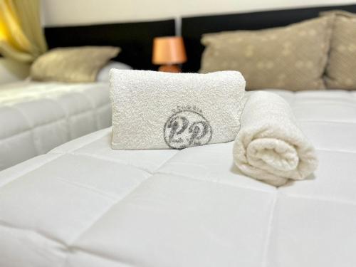 科洛尼亚-德尔萨克拉门托Hotel Perla del Plata的床上的毛巾和枕头