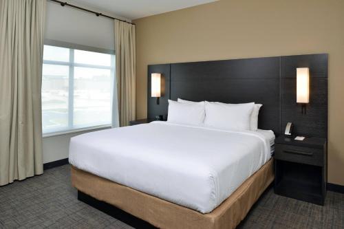 切斯特菲尔德Residence Inn by Marriott St Louis Chesterfield的一间卧室设有一张大床和一个大窗户