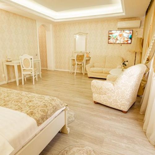 札勒乌Grand Hotel Baroc的一间卧室配有一张床、一张沙发和一张桌子