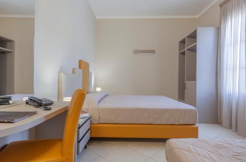 圣维托罗卡波吉卜力酒店的一间卧室配有一张床和一张带电脑的书桌
