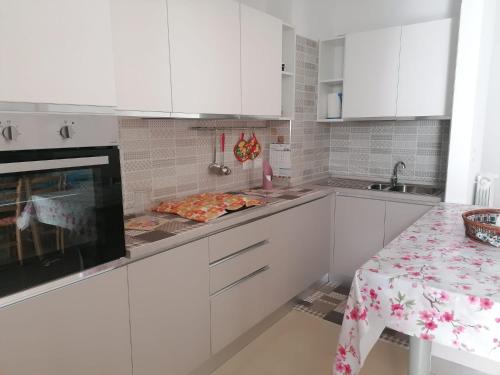 加拉蒂纳Albachiara的白色的厨房配有白色的橱柜和桌子