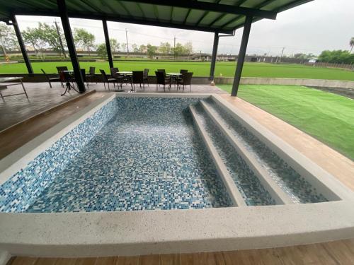 宜兰市慕研安農民宿 包棟 KTV 游泳池 羅東運動公園 22p的凉亭内的游泳池,配有桌椅