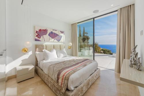 安德拉特斯Blue Sky Mallorca Luxury Villa的一间卧室设有一张大床,享有海景