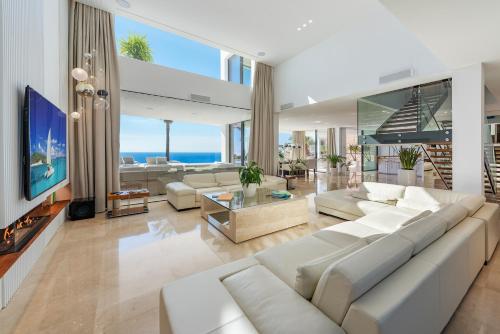 安德拉特斯Blue Sky Mallorca Luxury Villa的客厅配有白色家具和大电视