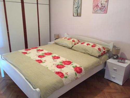 斯普利特米拉公寓的一间卧室,床上有红色的鲜花