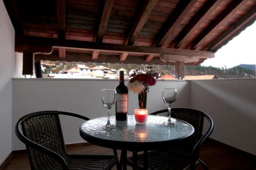 兹拉托格勒Бялата Къща 2的一张桌子,上面放着一瓶葡萄酒和两杯酒