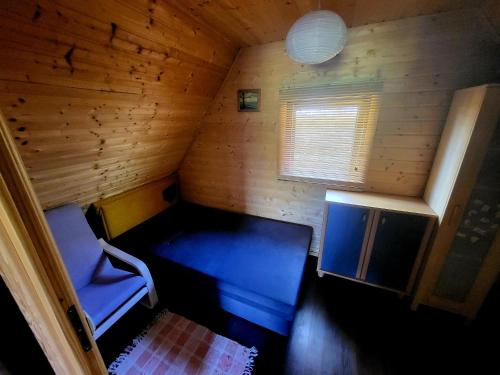 WądzynDomki na Górce的小房间设有蓝色的床和窗户