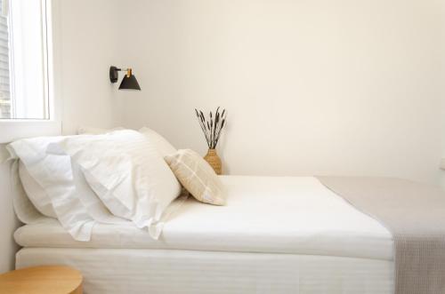 提诺斯Eleana Hotel的一张带白色床单和枕头的床