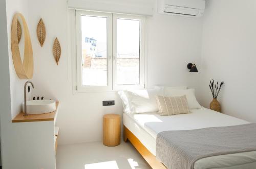 提诺斯Eleana Hotel的白色卧室设有床铺和水槽